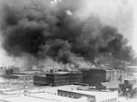 In this 1921 image provided by the Library of Congress, smoke billows over Tulsa, Okla. 