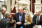 French Prime Minister Michel Barnier (center) talks to people at the National Assembly before French lawmakers vote on a no-confidence motion in Paris Wednesday.