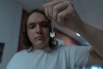 Ivan Sarancha shows Ukraine's coat of arms on a chain in dormitory of NGO Save Ukraine.