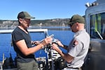 Two aquatic biologists Scott prepare a water sample at Crater Lake that will help them measure how quickly algae grows.