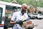 Abernathy sorts through letters and magazines on his delivery route. The Trump administration’s slashing of the U.S. government has helped push his eldest to leave a federal job to join the private sector.