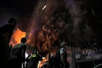 Firefighters and rescuers gather outside a computer shop hit in an Israeli airstrike in central Beirut, Sunday, Nov. 17, 2024.