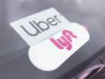Symbols for Uber and Lyft adorn Farhan Badel’s vehicle in Apple Valley, Minn.