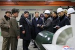 In this undated photo provided Thursday, Dec. 25, 2025, by the North Korean government, its leader Kim Jong Un, third left, visits a shipyard as he inspects a nuclear-powered submarine under construction at an undisclosed location in North Korea. Independent journalists were not given access to cover the event depicted in this image distributed by the North Korean government. The content of this image is as provided and cannot be independently verified. Korean language watermark on image as provided by source reads: "KCNA" which is the abbreviation for Korean Central News Agency. (Korean Central News Agency/Korea News Service via AP)