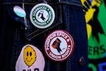 FILE - Employee Quint Palermo wears union pins on their jacket as Starbucks workers participate in a walkout and strike during the company's Red Cup Day Thursday, Nov. 16, 2023, at the company's first Reserve roastery in Seattle.