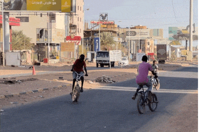 Kids show off their bike prowess on a deserted street in Khartoum, recaptured by the Sudanese army in March.