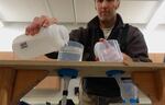 ODFW's Shaun Clements filters stream water in hopes of capturing synthetic DNA he released.