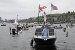A protester reels in a fake fish near poles marking a six-foot social distance on a boat on Lake Union in Seattle on Sunday during a protest against Washington state's current ban on recreational fishing.