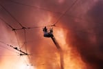 Firefighters try to put out a fire at a city book market following a Russian missile attack in Kyiv, Ukraine early Sunday, Aug. 16, 2026.