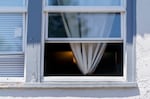 An apartment dweller keeps the windows open, seeking relief from the heat, in Portland, June 27, 2022.