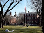 A security guard walks past a flag at half-staff on the main green of Brown University in Providence, R.I., on Dec. 18, 2025.