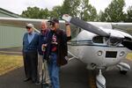 Vietnam War veteran Simon Rowland (right) prepares to fly in a P-Model Cessna plane with pilot Bill Roller (center) and World War II veteran Guy McMackin (left).