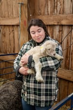 LillyAnne Keely holds a newborn lamb in the barn at Sterling College in Craftsbury Common, Vermont, which focuses on agriculture and related disciplines. The college has announced that it will close at the end of this semester.