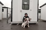 Charlene Brown and her dog, Charlie, sit in front of her sleeping pod at the Clinton Triangle shelter in Southeast Portland, Feb. 27, 2024. Brown has lived at the shelter since July, and is eager to move into permanent housing.