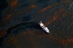 A boat travels through crude oil leaked from the Deepwater Horizon wellhead near Louisiana.