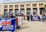 Around 30 people gathered in front of Eugene's main Post Office to rally against postal privatization.