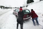 Friends help push Jacey Bustad's car out of a snow bank after it got stuck halfway up Mt. Scott Wednesday night.
