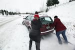 Friends help push Jacey Bustad's car out of a snow bank after it got stuck halfway up Mt. Scott Wednesday night.