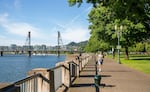 A jogger runs along the waterfront in Gov. Tom McCall Waterfront Park in downtown Portland, Ore., on Tuesday, June 23, 2020. The park, named after Oregon's famous environmentalist former governor, sits where a highway once ran.