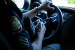 Police Sgt. Kristi Butcher, supervisor of the Portland Police Bureau’s Human Trafficking Unit, uses a police radio system to check in with fellow unit members during a directed patrol mission in Portland, Ore., in July. A directed patrol mission aims to combat human trafficking activity and is carried out by a team of police officers, an FBI agent and victim advocates.