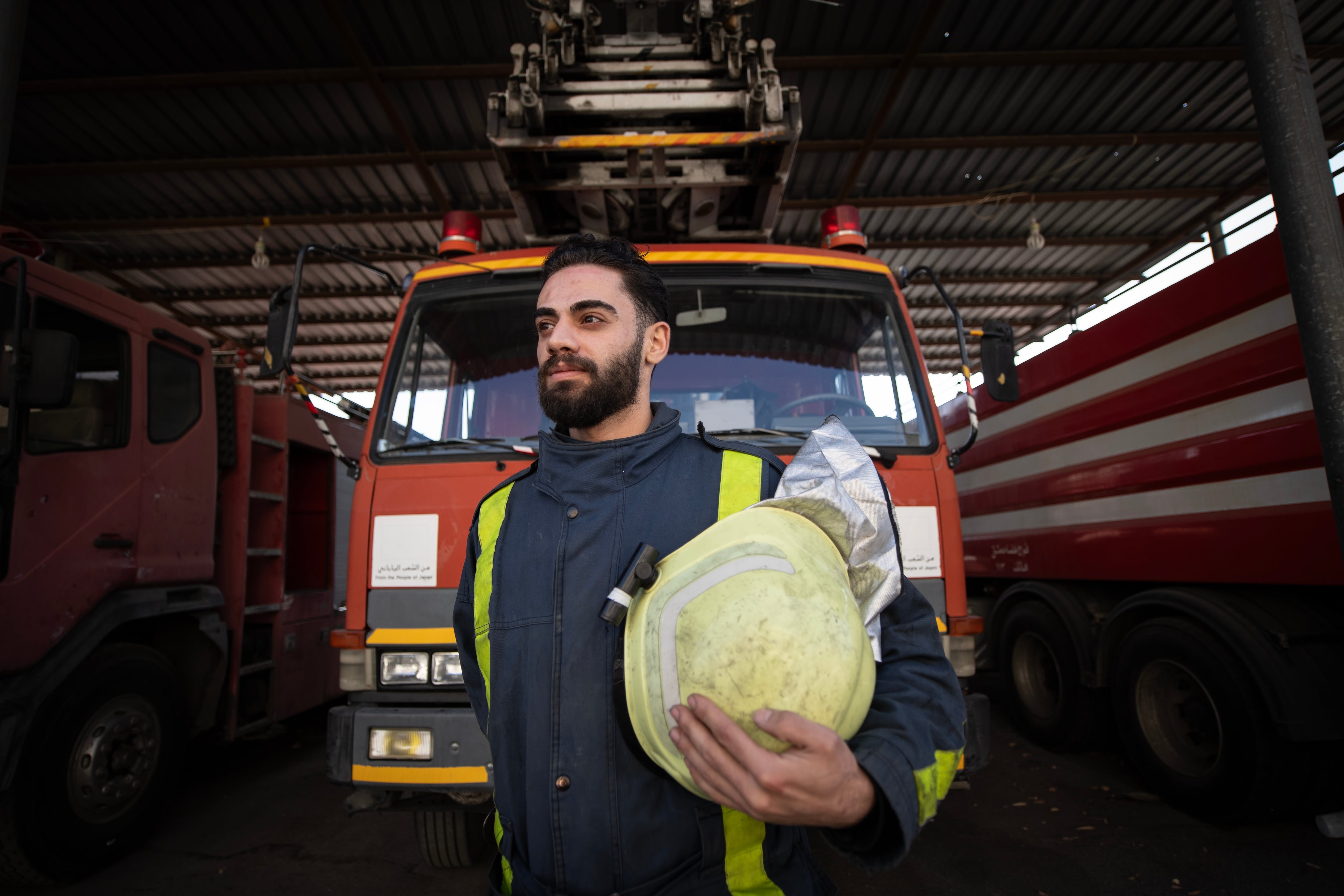 Mohammed Khdeir poses for a portrait in front of a firetruck.