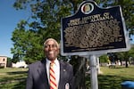 Johnny Ford, former mayor of Tuskegee, Ala., and a current council member, stands near an accurate historical marker that was installed in the town square during his term as mayor. Ford is currently fighting to have a Confederate marker and statue removed from the square.
