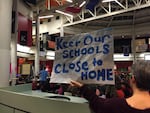 A Beaverton parent holds up a sign that reads "Keep Our Schools Close To Home." A boundary committee has been working to rewrite lines all over the district.