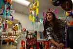 Yamely Chavez Kennedy decorates her ofrenda with balloons at Colima Market in Bend, Ore., on Oct. 30, 2024.