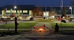 People bring items to Silver Rail Elementary School in Bend, Ore., Oct. 15, 2026, as the investigation continues at the scene. 