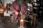 Darryl Nelson uses techniques of his trade handed down generations. At his anvil, he works a piece of heated steel with hammer and chisel, tools he made himself.  