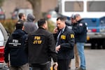An FBI agent, among other investigators and emergency personnel from various organizations, works at the scene of a U.S. Border Patrol shooting of two people at building three of Adventist Health on the 10200 block of Southeast Main Street in Portland on Jan. 8, 2026.