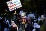 Demonstrator Karen Louise Gonsalves, of Boston, center, displays a placard, Wednesday, Nov. 4, 2020, during a protest on the Boston Common, in Boston, as ballots continue to be counted in some battleground states for the general election. (AP Photo/Steven Senne)