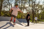 Carlos Reynoso (middle) watches on April 30, 2023 as his son, Nakiah Reynoso (left), skates at the same park where Carlos learned to skate when he was growing up. But 9-year-old Nakiah gets to learn at the new and improved version of the park.