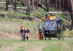 Searchers exit a Brim helicopter after finding 69-year-old Harry Burleigh alive on Sunday, May 23, 2021.