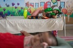 Rina cradles her 4-month-old son, Akaid, who is a measles patient at DNCC Hospital in Dhaka, Bangladesh.