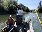 In this September 2021 photo, Helena Linnell of the Coquille Tribe (seated) and Gary Vanderohe of the ODFW (center) take his agency's electrified boat up the Coquille River to zap and remove invasive bass.