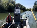 In this September 2021 photo, Helena Linnell of the Coquille Tribe (seated) and Gary Vanderohe of the ODFW (center) take his agency's electrified boat up the Coquille River to zap and remove invasive bass.