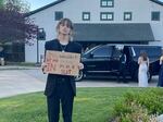 Hayes stood outside of the prom holding a sign that read, "they wouldn't let me in because i'm in a suit."