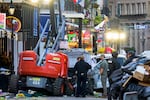 People stand on Bourbon street looking for evidence after car rams crowd.