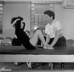 Bonnie Prudden helps a student with sit-ups.