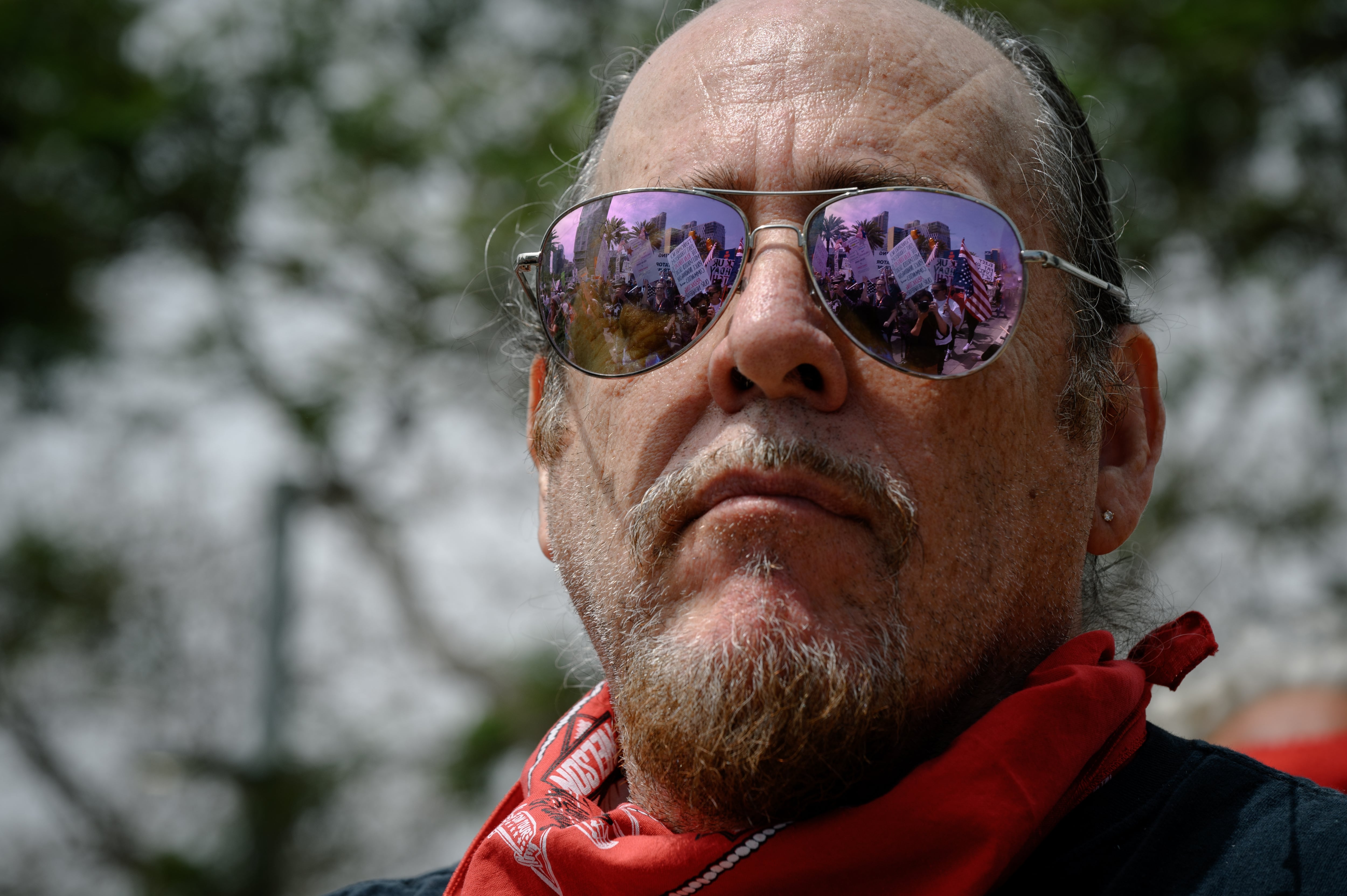San Diego: A musician watches as thousands of protestors, reflected in their sunglasses, march through downtown.