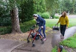 Shelby Boyd struggles to push her walker up a slight incline, followed by her mother at their apartment complex in Lake Oswego, Aug. 11, 2022. Boyd is one of the thousands of Oregonians who've missed more than one year of work because of long COVID-19.