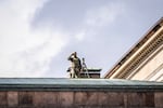 A sniper is seen on a roof as police secures the venue of a meeting of European Union leaders at Christiansborg Palace in Copenhagen, Denmark, on Wednesday.