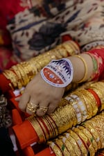 Ripa Ahmed, 50, a local business owner in Jackson Heights, displays her voter sticker as she tends to clients inside her store.