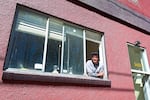 Anis Mojgani leans out the window of his Portland studio on April 17, 2024.