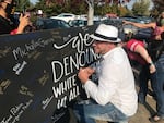 Nicholas Dieringer signs a board denouncing white supremacy in Bend on Oct. 3, 2020, after planning a pro-Trump rally in the same park as a picnic hosted by racial justice groups.