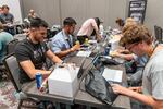 Participants at the 2023 Def Con hacker convention, trying to subvert AI chatbots as part of a contest to test the systems' vulnerabilities.