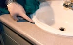 A Salem police detective points to a faint spot of blood on the bathroom sink inside Harriet Thompson's apartment in March 1998. DNA tests would later reveal that this blood did not belong to Thompson or Jesse Johnson, the man who was eventually convicted of her murder.