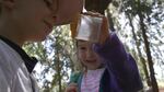 Kids at Fiddleheads Forest School inspect a praying mantis. 