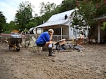 Teresa Reynolds sits exhausted as her neighbors remove debris from their flood-ravaged homes in Hindman, Ky., in July 2022. The deadly floods were caused by torrential rains. Climate change makes such record-breaking rainstorms more common in much of the United States.
